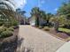 Well-maintained home with lush landscaping, featuring palm trees and a brick driveway at 7253 Seville Dr., Myrtle Beach, SC 29572