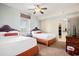 Comfortable bedroom featuring two beds, a ceiling fan, and an adjacent door to the bathroom at 8121 Amalfi Pl. # 7-604, Myrtle Beach, SC 29572