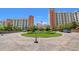 Beautiful exterior of a resort featuring a circular driveway, well-manicured landscaping and palm trees at 8121 Amalfi Pl. # 7-604, Myrtle Beach, SC 29572