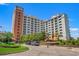 Beautiful exterior of a multi-story condominium complex with manicured landscaping and a circular driveway entrance at 8121 Amalfi Pl. # 7-604, Myrtle Beach, SC 29572