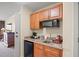 Efficient kitchenette with wooden cabinets, granite countertops, and modern appliances for convenient in-room dining at 8121 Amalfi Pl. # 7-604, Myrtle Beach, SC 29572