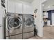 Well-equipped laundry room with modern washer, dryer, white cabinets, and light wood floors at 1009 Oak Marsh Ln., North Myrtle Beach, SC 29582
