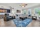 Bright living room features a comfortable gray sectional, blue starfish rug, and ceiling fan at 1009 Oak Marsh Ln., North Myrtle Beach, SC 29582