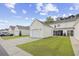 Charming exterior view showcasing the home with a detached garage and a well-maintained lawn at 1065 Harvester Circle, Myrtle Beach, SC 29579
