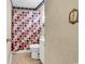 Modest bathroom featuring a toilet, vanity, patterned shower curtain, and vintage wallpaper at 1104 Ragin St., Myrtle Beach, SC 29577