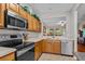 Functional kitchen featuring wood cabinetry, a range, and a view of the living room at 112 Olde Towne Way # 5, Myrtle Beach, SC 29588