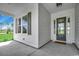 Welcoming porch features white siding and trim, a modern front door, and outdoor lighting at 1142 Fiddlehead Way, Myrtle Beach, SC 29579