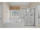 Bathroom showcasing a soaking tub, glass-enclosed shower, and a window with natural light at 1315 Cherry Dr., Surfside Beach, SC 29575