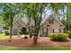 Charming brick home featuring mature trees, manicured landscaping, and an inviting front entrance at 1315 Cherry Dr., Surfside Beach, SC 29575