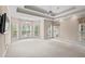 Spacious primary bedroom featuring tray ceiling, recessed lighting, chandelier, and plentiful windows at 1315 Cherry Dr., Surfside Beach, SC 29575