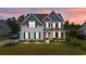 Charming two-story home with blue accents, covered porch, and a well-maintained lawn at sunset at 1325 Bermuda Grass Dr., Myrtle Beach, SC 29579