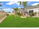 Landscaped backyard with lush green grass, tropical palms, and an inviting outdoor patio at 1340 Jolly Roger Dr., North Myrtle Beach, SC 29582