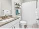 Bright bathroom features a shower with a white shower curtain and granite countertops at 1340 Jolly Roger Dr., North Myrtle Beach, SC 29582