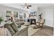 Comfortable living room with a fireplace, ceiling fan, and large windows offering ample natural light at 1340 Jolly Roger Dr., North Myrtle Beach, SC 29582