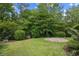 Lush backyard featuring a brick paver area, beautiful landscaping, and black metal fencing at 1444 Thames Ct., Myrtle Beach, SC 29577