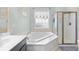 Bathroom featuring soaking tub, glass-enclosed shower, and natural light at 1444 Thames Ct., Myrtle Beach, SC 29577