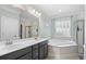 Bathroom with double sink vanity, soaking tub, separate glass shower, and decorative leaf wall art at 1444 Thames Ct., Myrtle Beach, SC 29577