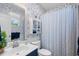 Nautical-themed bathroom with blue-and-white patterned wallpaper, a vanity sink, toilet, and shower with a striped curtain at 1444 Thames Ct., Myrtle Beach, SC 29577