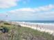 Scenic view of a beach with natural dunes, clear ocean waters and sunny skies, perfect for relaxation at 1444 Thames Ct., Myrtle Beach, SC 29577