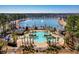 Beautiful aerial view of community pool and nearby pond surrounded by mature trees and lush landscaping at 1444 Thames Ct., Myrtle Beach, SC 29577