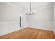 Spacious dining room featuring hardwood floors, wainscoting, and modern light fixture at 1533 Murrells Landing Rd., Conway, SC 29526