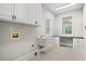 Well-lit laundry room featuring a utility sink, countertop, and storage cabinets at 1533 Murrells Landing Rd., Conway, SC 29526