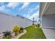 The backyard has a white fence with landscaping, small trees, and green grass at 1549 Coastal Cove Ln, Calabash, NC 28467