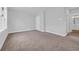 A bright bedroom is seen with carpet, white walls, and doorway to the bathroom at 1549 Coastal Cove Ln, Calabash, NC 28467