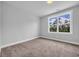 Empty bedroom with a window featuring natural light and neutral carpeting and walls at 1549 Coastal Cove Ln, Calabash, NC 28467