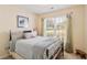 Bedroom with patterned comforter, grey walls, neutral carpet, and window with wood blinds and curtains at 1566 Bessent Ave., Little River, SC 29566