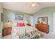 Bedroom with floral bedspread, neutral carpet, sage green walls, ceiling fan, and wooden dressers at 1566 Bessent Ave., Little River, SC 29566