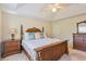 Primary bedroom with carved bed, white comforter, bedside table, dresser, neutral carpet, and ceiling fan at 1566 Bessent Ave., Little River, SC 29566