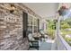 Cozy front porch featuring comfortable chairs, hanging plants, and classic brick architecture at 1566 Bessent Ave., Little River, SC 29566