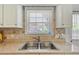 A kitchen sink with stainless steel faucet fixtures is located below a window with closed blinds at 1566 Bessent Ave., Little River, SC 29566