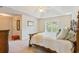 Serene main bedroom features a tray ceiling, a large window, and a plush bed with decorative pillows at 1566 Bessent Ave., Little River, SC 29566
