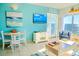 Coastal living room with TV, dining area, and ocean view door to outside at 1605 S Ocean Blvd. # 1909, Myrtle Beach, SC 29577