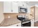 Modern kitchen featuring stainless steel microwave and oven with white cabinets and granite countertops at 189 Ella Kinley Circle # 201, Myrtle Beach, SC 29588