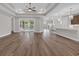 Open-concept living space featuring sleek wood flooring, recessed lighting, and view to pool at 1936 Indigo Cove Ln, Calabash, NC 28467