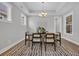 Bright dining room featuring a modern chandelier, wood floors, and a stylish area rug at 1940 Indigo Cove Ln, Calabash, NC 28467
