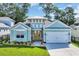 Charming, light blue single story home with a two car garage, lovely landscaping, and a sunny yellow front door at 1940 Indigo Cove Ln, Calabash, NC 28467