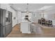 Bright kitchen featuring white cabinetry, stainless steel appliances, an island, and bar stool seating at 1940 Indigo Cove Ln, Calabash, NC 28467