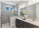 Modern bathroom featuring double sinks, stylish vanity, a glass-enclosed shower, and natural light at 1946 Indigo Cove Ln, Calabash, NC 28467