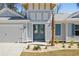 Charming home exterior featuring a blue front door, garage, and beautiful landscaping at 1946 Indigo Cove Ln, Calabash, NC 28467