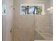 Contemporary shower features neutral tile, glass door, and a window offering natural light at 1946 Indigo Cove Ln, Calabash, NC 28467
