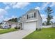 Two-story home featuring a garage, black door, and meticulously manicured landscaping at 2059 Borgata Loop, Longs, SC 29568
