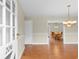 Open-concept entryway with wood floors, a modern chandelier, and a view of the dining room at 2096 Golden Leaf Rd., Galivants Ferry, SC 29544