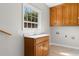 Functional laundry room featuring wooden cabinets, a utility sink, and tile flooring at 2096 Golden Leaf Rd., Galivants Ferry, SC 29544