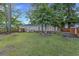 Spacious backyard featuring green grass, mature trees, wood fence, and patio space with picnic table at 2519 Reta St., Conway, SC 29526