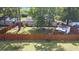 View of a spacious backyard with a wooden fence, green grass, mature trees, and a storage shed at 2519 Reta St., Conway, SC 29526