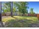 Spacious backyard featuring green grass, mature trees, wood fence, patio space, and a storage shed at 2519 Reta St., Conway, SC 29526